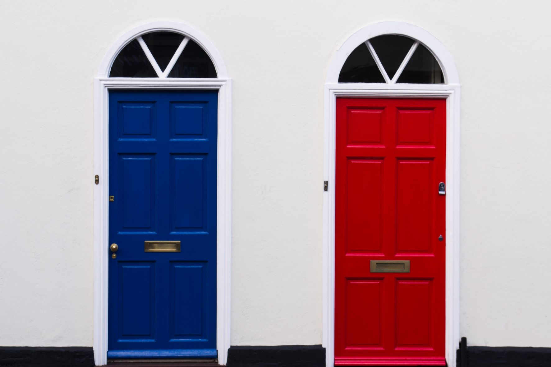 Picture of a blue and red door on a white building.